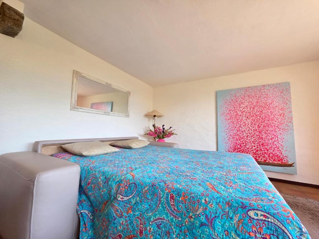 a bedroom with a large bed with a blue blanket at Casa Leyian - Free parking in Brissago