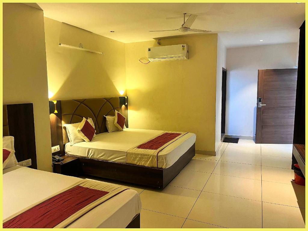 Una habitación de hotel con dos camas y balcón. en SEA VIEW from rooftop HOTE S NIWAS ! PURI near Swargadwar - Golden Beach - Jagannath Temple - Parking - Fully Air Conditioning Rooms - BEST HOTEL IN PURI, en Puri