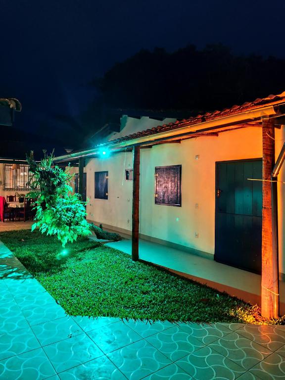 a house with a green light in front of it at Chalés Com Quadra de Areia in São Sebastião