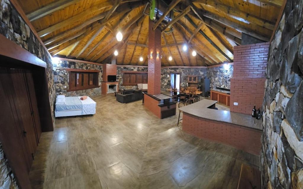 a large living room with a stone wall at SIG - Rancho Desiam - Serra Gaúcha in Gramado