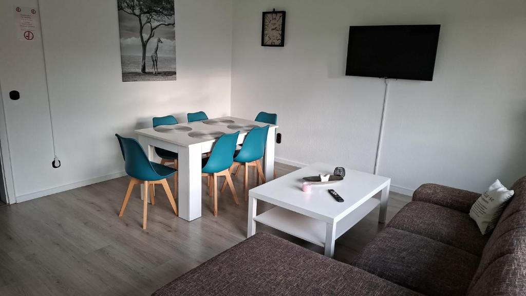 Work and Stay Plettenberg 90 Qm 7 Betten 3 Schlafzimmer mit Balkon und Kraftraum 44 oben في بليتنبرغ: غرفة معيشة مع طاولة وكراسي وأريكة