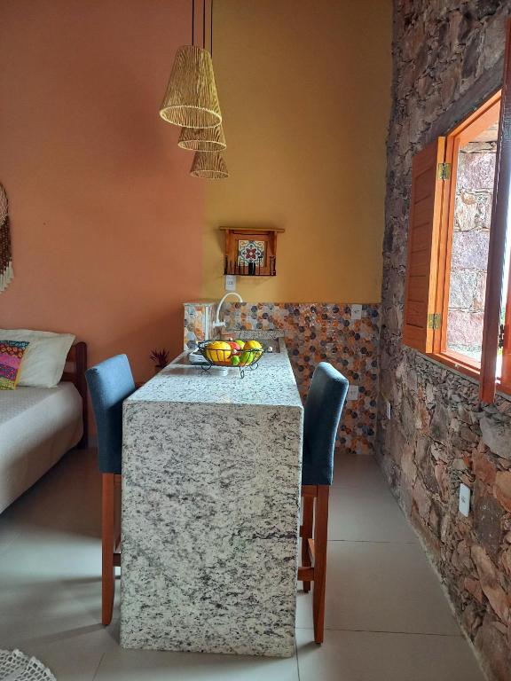 a kitchen with a table with a bowl of fruit on it at Loft de Cristal Igatu in Andaraí