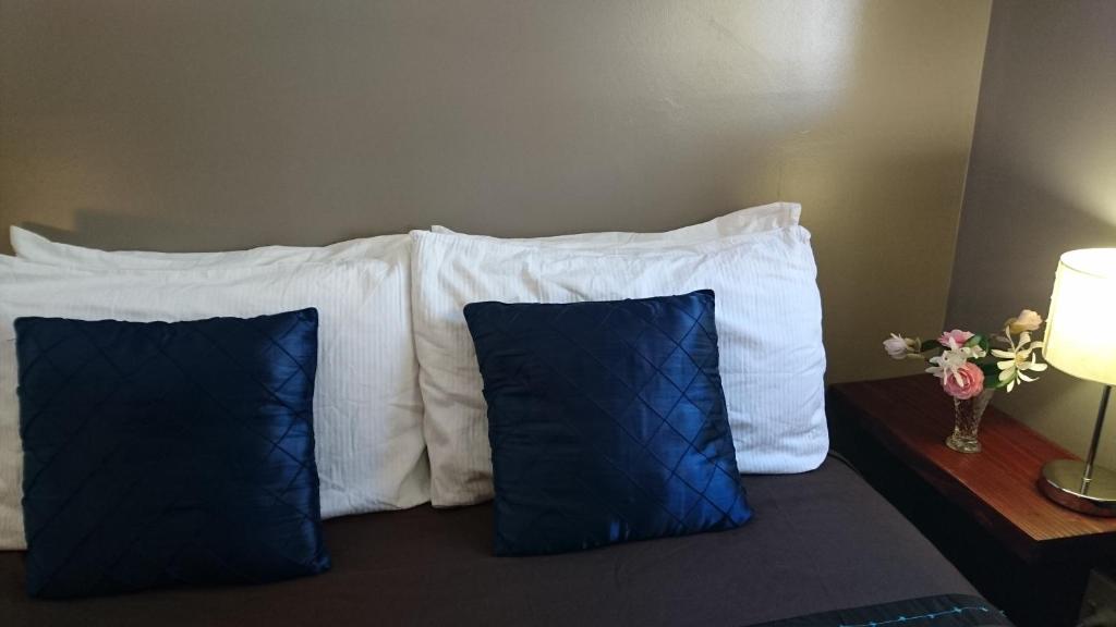 a bed with white pillows and blue at Waitapu Springs B&B in Takaka