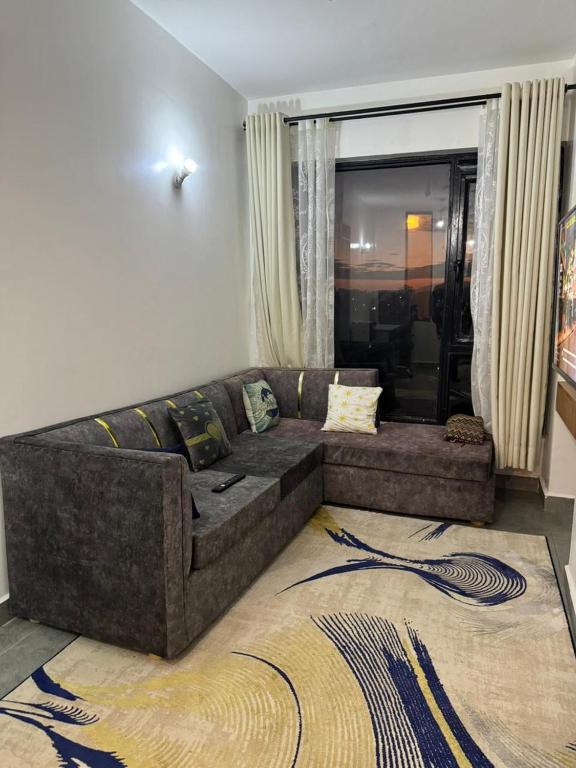 a living room with a brown couch in a room at BonBon Residency in Kiambu