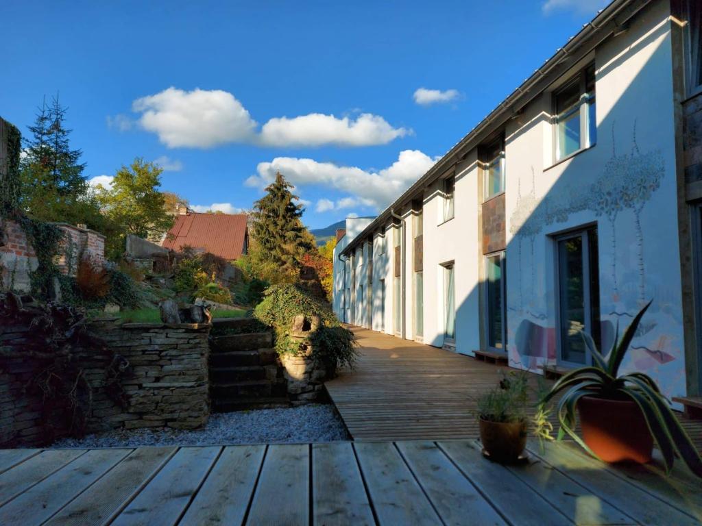 a wooden deck in a yard next to a building at Resort Papírna50 in Černý Dŭl