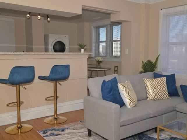 a living room with a couch and two blue chairs at The Cozy Luxe Retreat, Central West End in Saint Louis