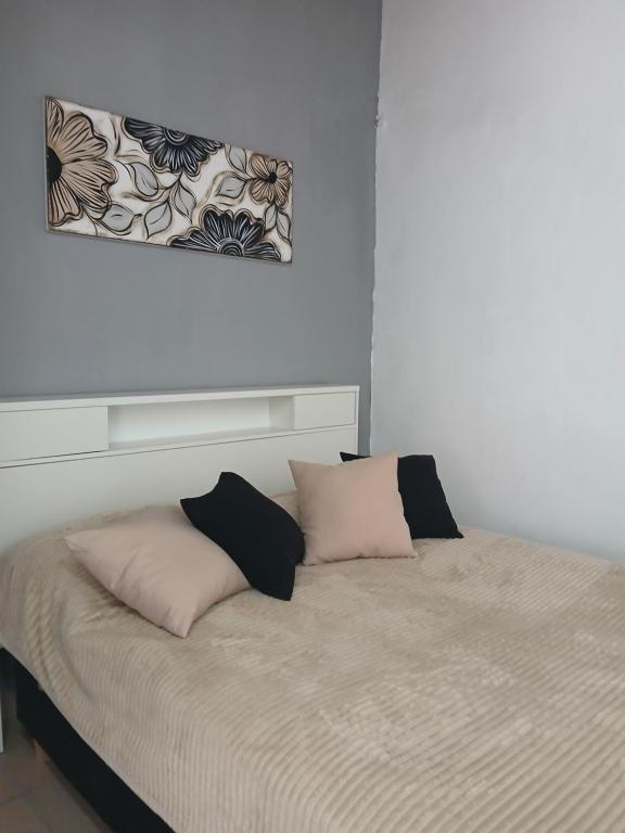 a bed with two pillows on it in a room at MyM in Merlo