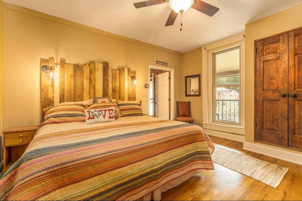 a bedroom with a large bed and a ceiling fan at All Aboard Stylish Downtown Loft, Walk to Restaurants, Shops, Train in Bryson City