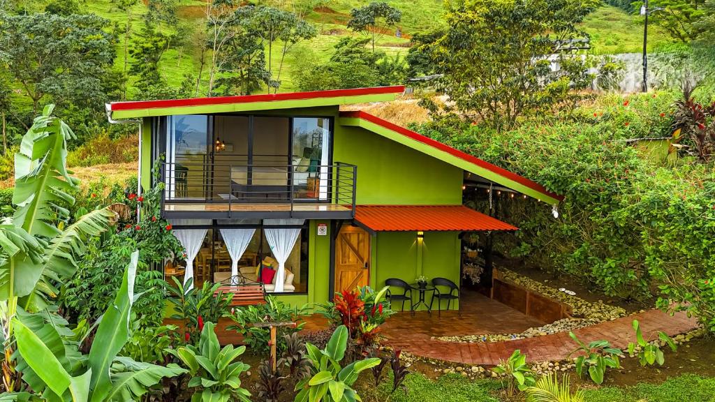 a green house with a red roof at Cabañas Caeli, El Colibri, NEW La Fortuna Rainforest Cabin w Panoramic Views in San Francisco