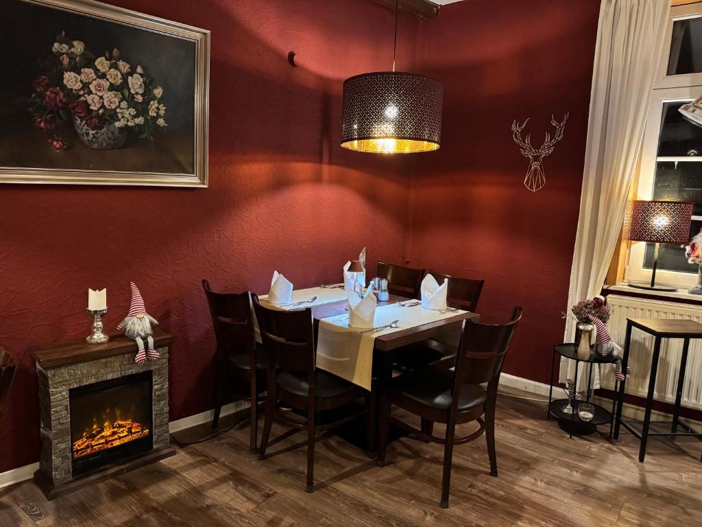 a dining room with a table and a fireplace at Harzhotel Warnstedter Krug in Thale