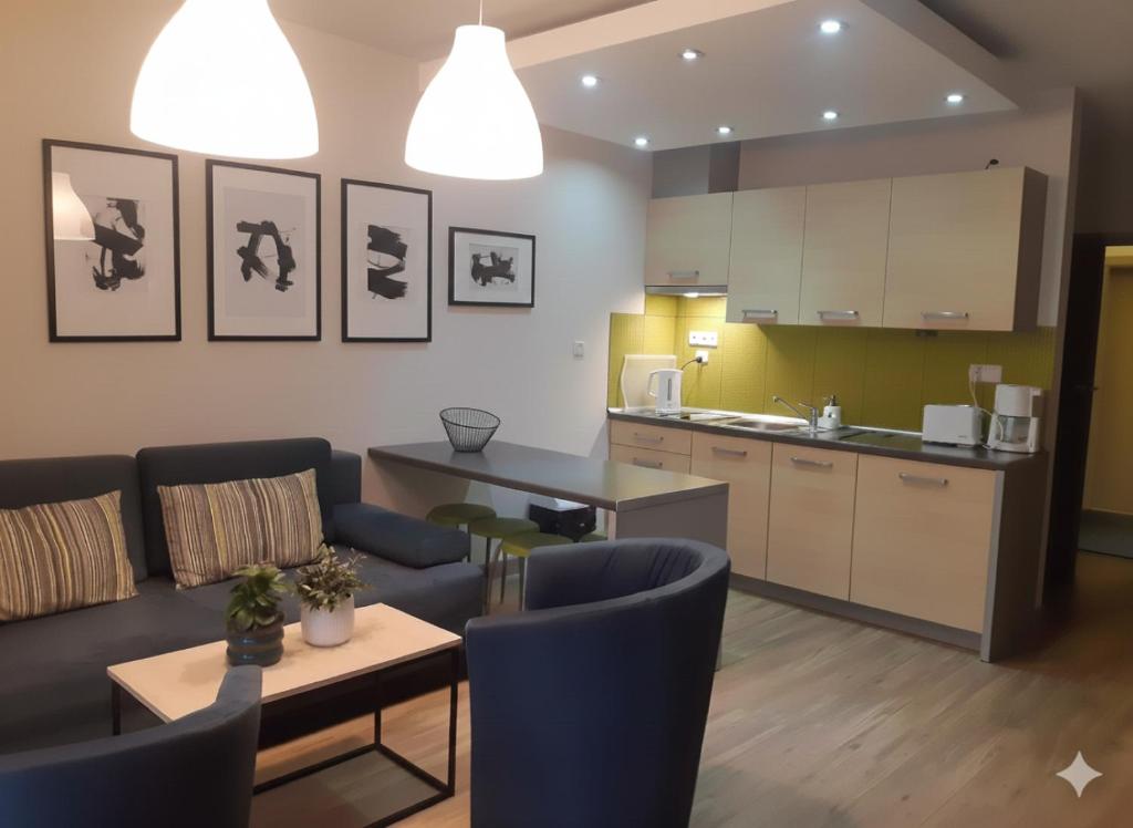 een woonkamer met een bank en een keuken bij domy szeregowe Nasza Chata - 4 minuty od plaży in Pobierowo