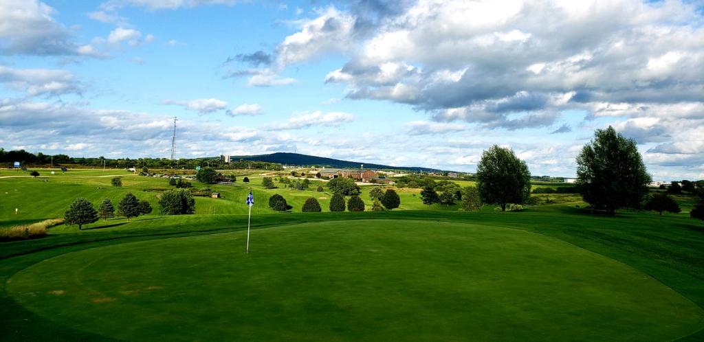a view of a golf course with a green field at Deer Valley Lodge in Barneveld