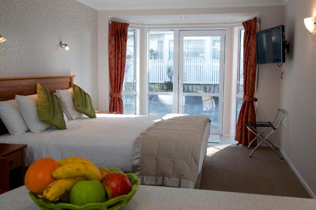 ein Hotelzimmer mit einem Bett und einer Obstschale in der Unterkunft Bucket Tree Lodge in Tawa