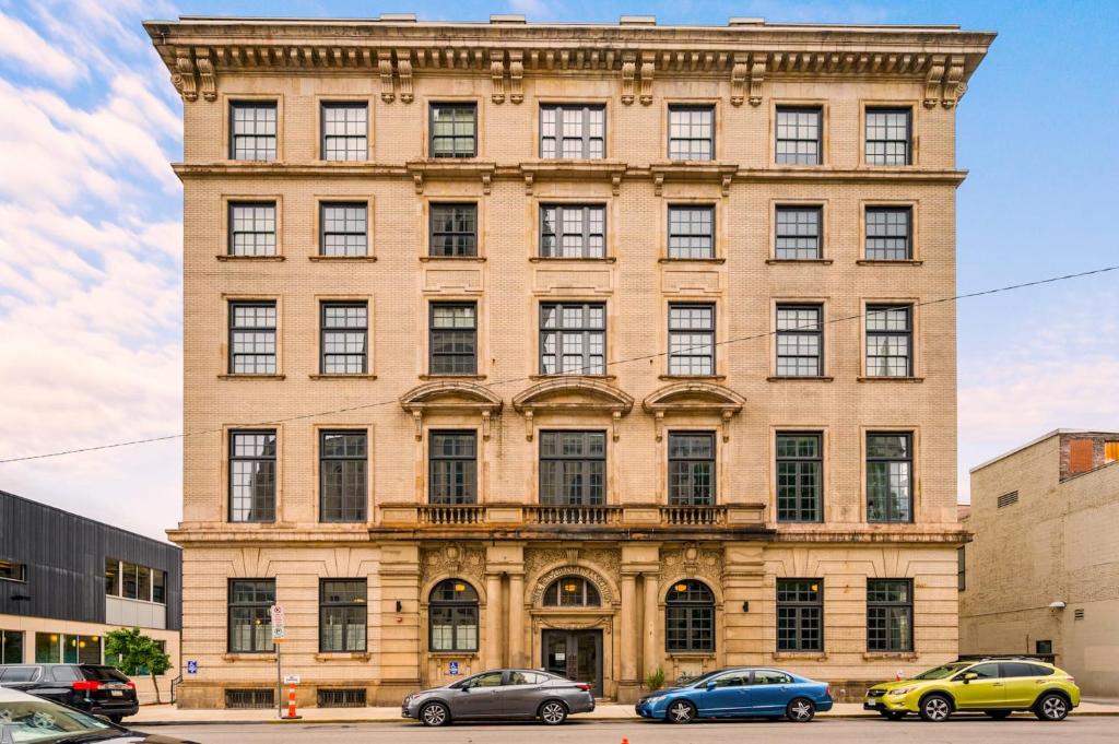a large brick building with cars parked in front of it at The Maverick By Kasa in Pittsburgh