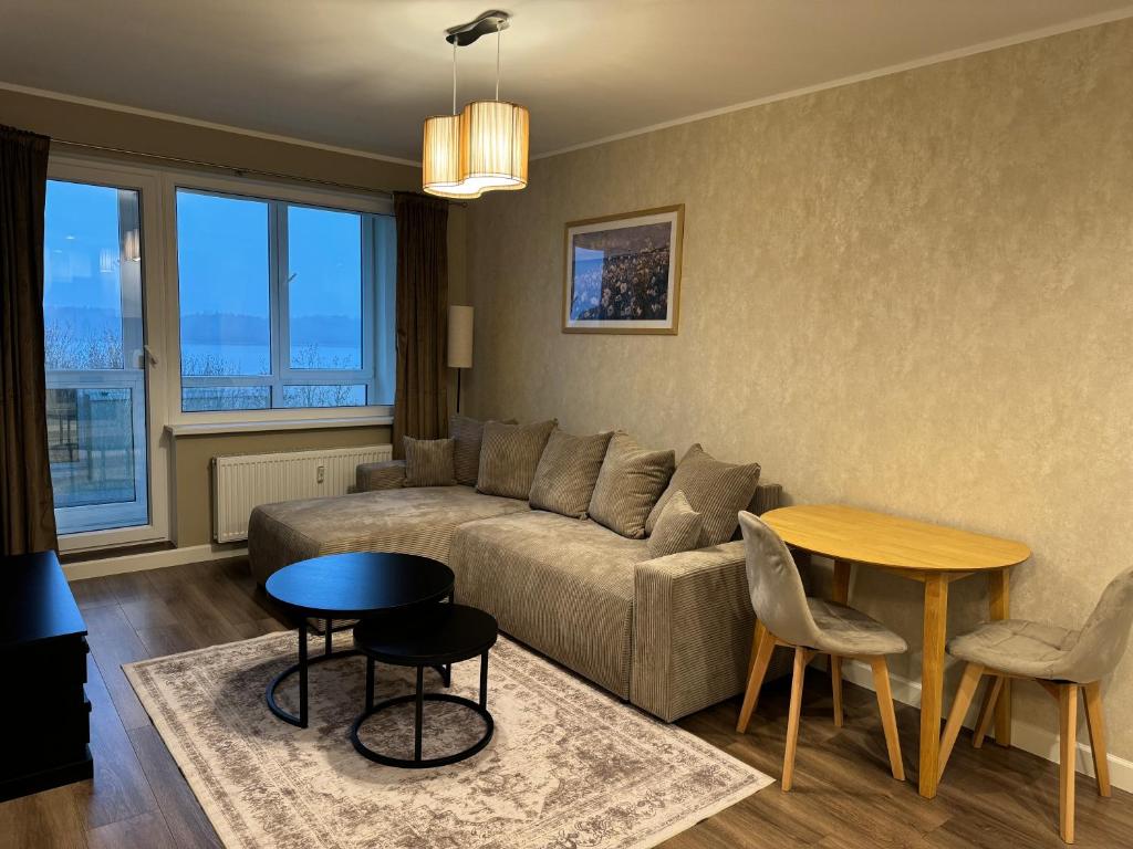 a living room with a couch and a table at Lake View Apartment in Telšiai