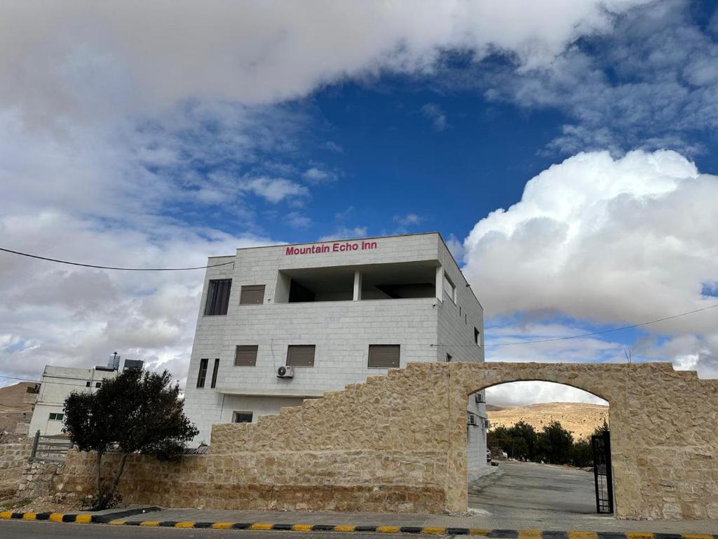 un edificio con un arco delante en Mountain Echo Inn, en Taiyiba