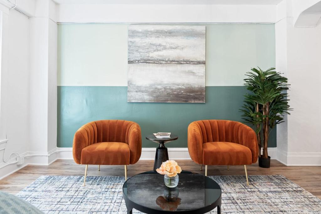two orange chairs and a table in a living room at Kasa La Monarca San Francisco in San Francisco