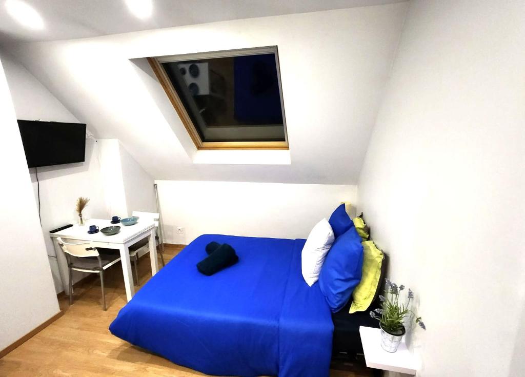 a living room with a blue couch and a table at Studio place Victor Hugo in La Celle-sous-Gouzon