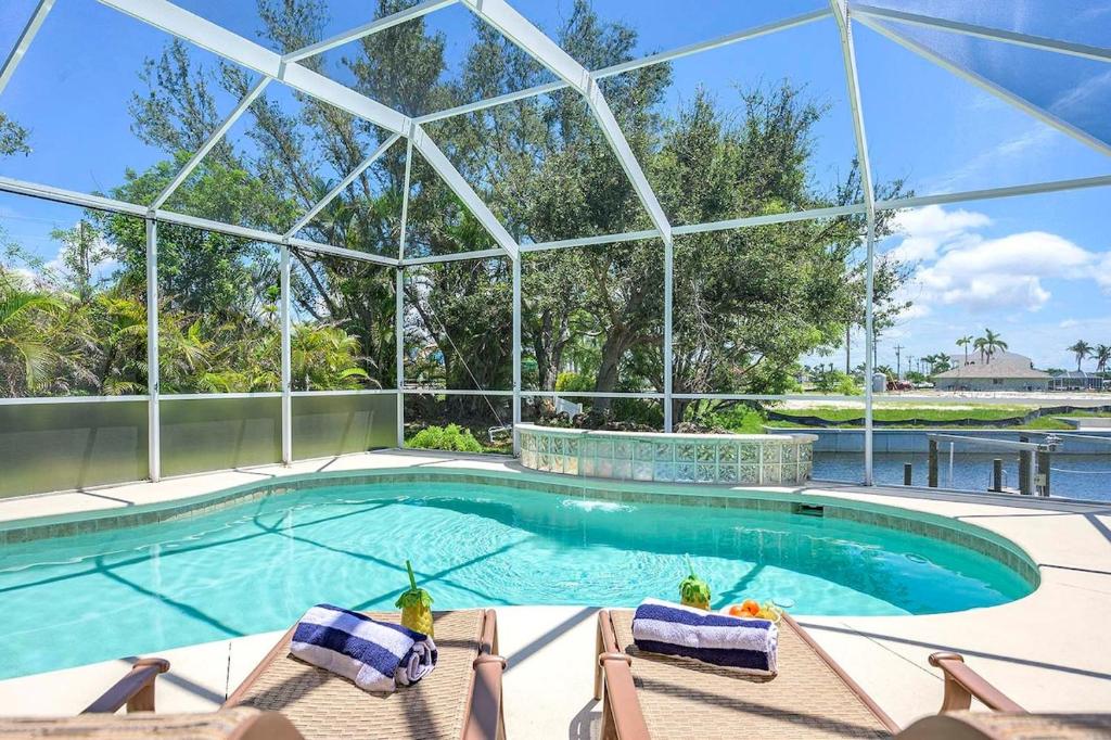a swimming pool with chairs and a large glass building at Surfside in Cape Coral