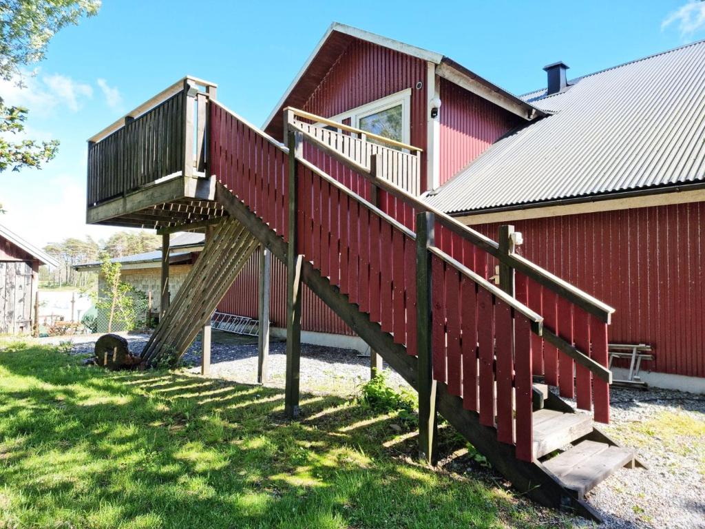 Cosy rural apartment close to Nösund SE09122 في Strand: درج خشبي يؤدي إلى منزل أحمر