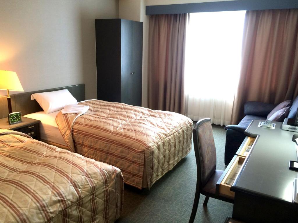 Postel nebo postele na pokoji v ubytování Hotel Crown Hills Takaoka