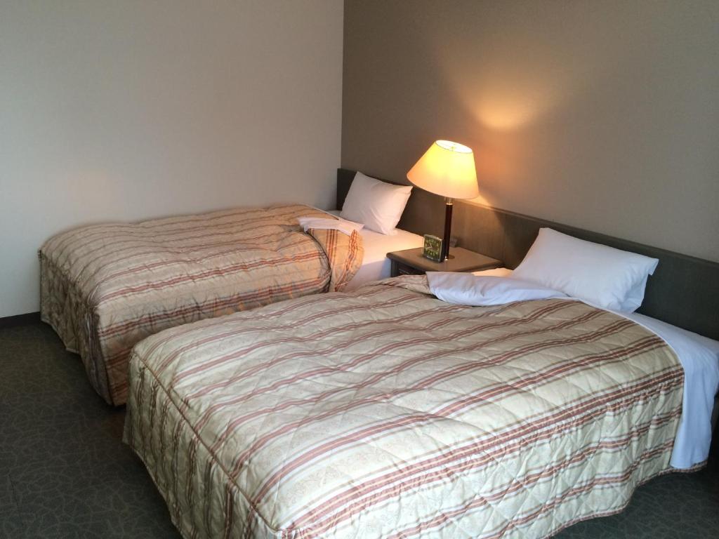 Postel nebo postele na pokoji v ubytování Hotel Crown Hills Takaoka