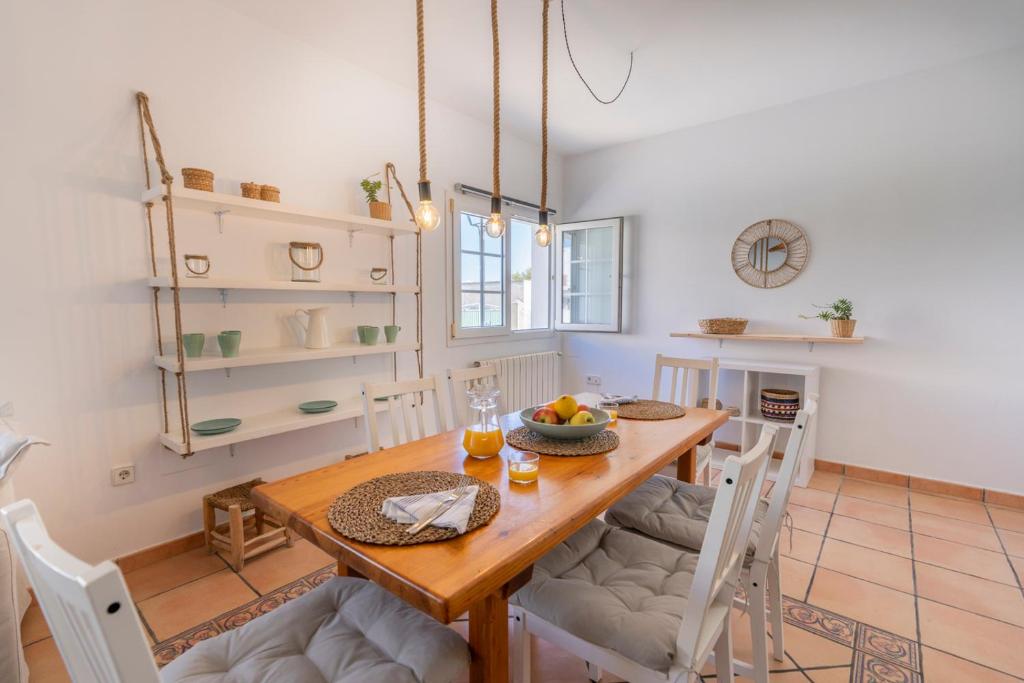 Casa Lucia a 500 m de la playa - Formentera Natural في لا سافينا: غرفة طعام مع طاولة وكراسي خشبية