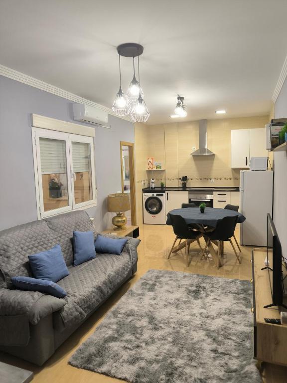 a living room with a couch and a table and a kitchen at Luxury Monte 65 in Tomelloso