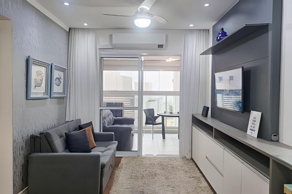 un soggiorno con un divano e una TV di Brisa do Mar - Varanda/2 qtos/Est/Ar a Campo Grande