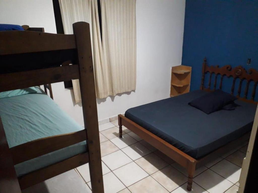 een slaapkamer met een bed en een stapelbed bij Pousada Blue Beach House in Peruíbe