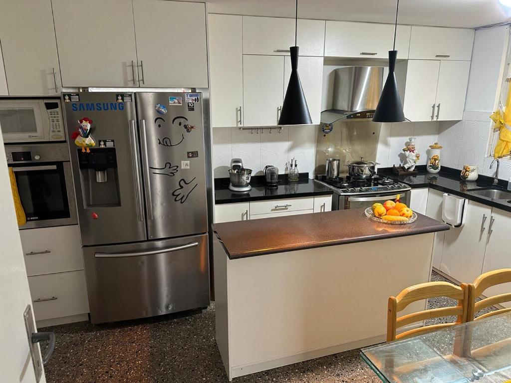 eine Küche mit einem Kühlschrank und einer Schale mit Obst auf der Theke in der Unterkunft como en tu casa mollendo in Mollendo