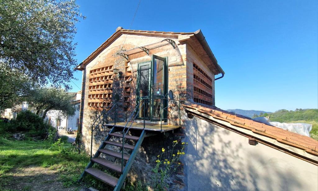 a house with a staircase on the side of it at fienile di frida in Lucca