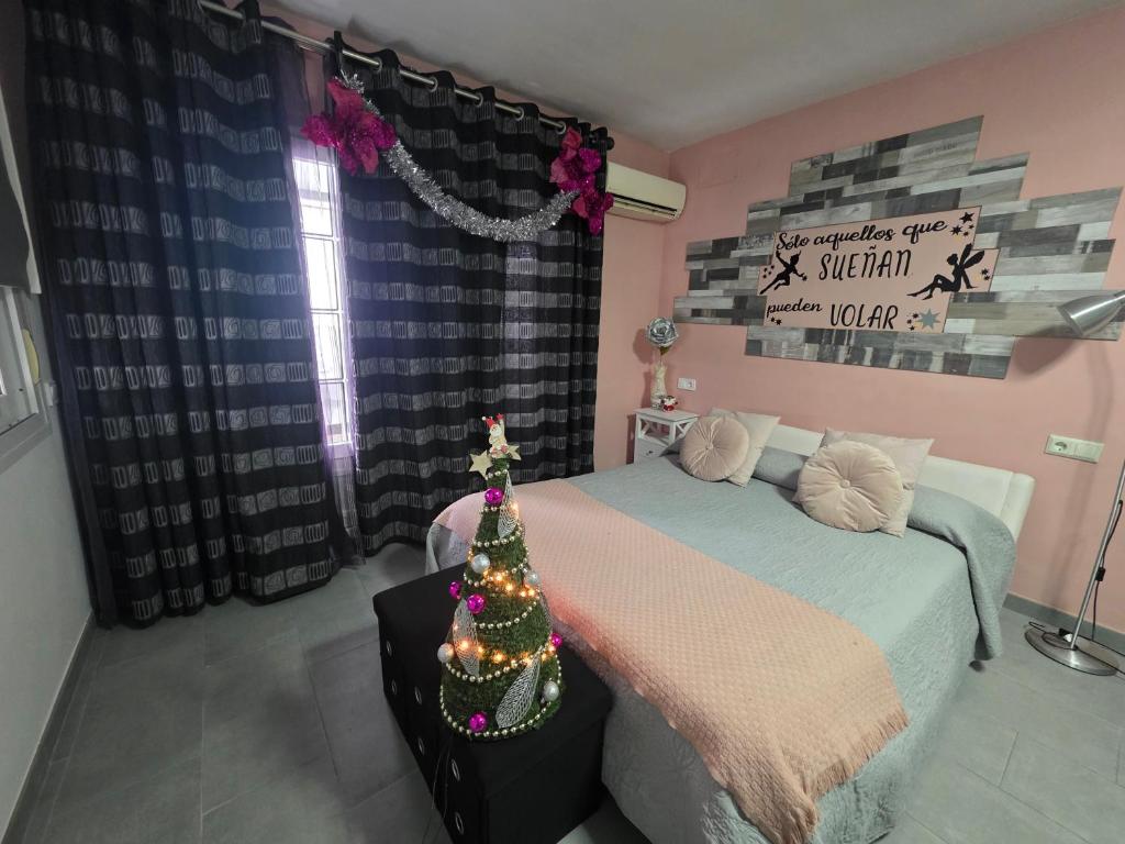 a bedroom with a bed with a christmas tree on it at El nido de la Galería in Setenil