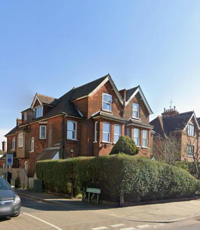 a large brick house with a hedge in front of it at Apartment Masons Hill in Bromley