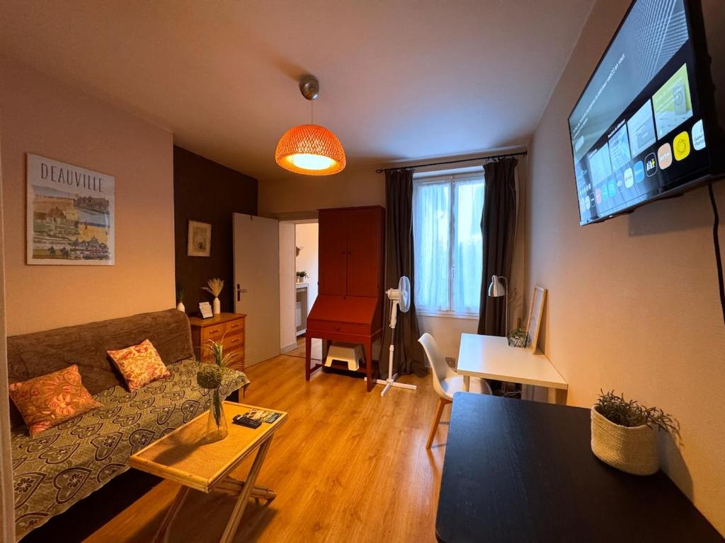 Una sala de estar con un sofá y un televisor de pantalla plana. en Le Repaire des Sablons 2 Pers 150m place du marche, en Fontainebleau