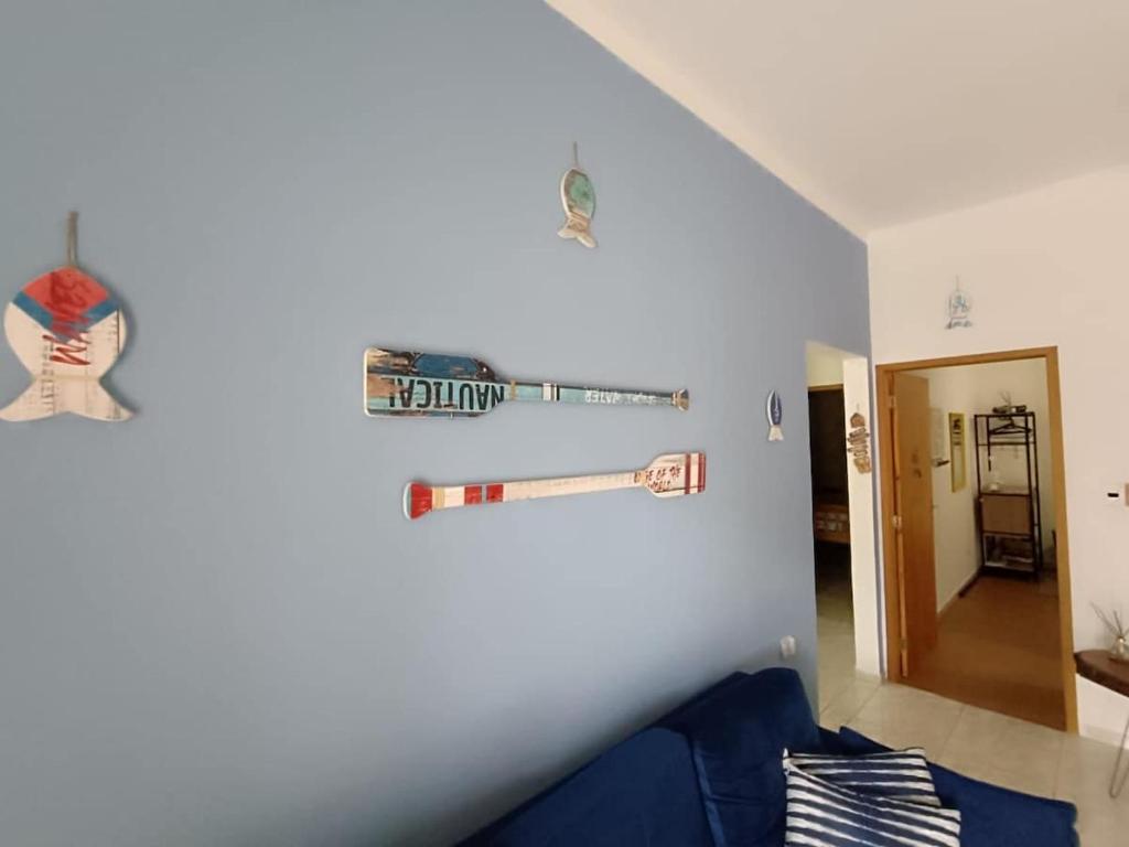 House with Atlantic Forest in the background - Saíra Sete Cores في بيرتيوغا: غرفة معيشة مع أريكة زرقاء وجدار