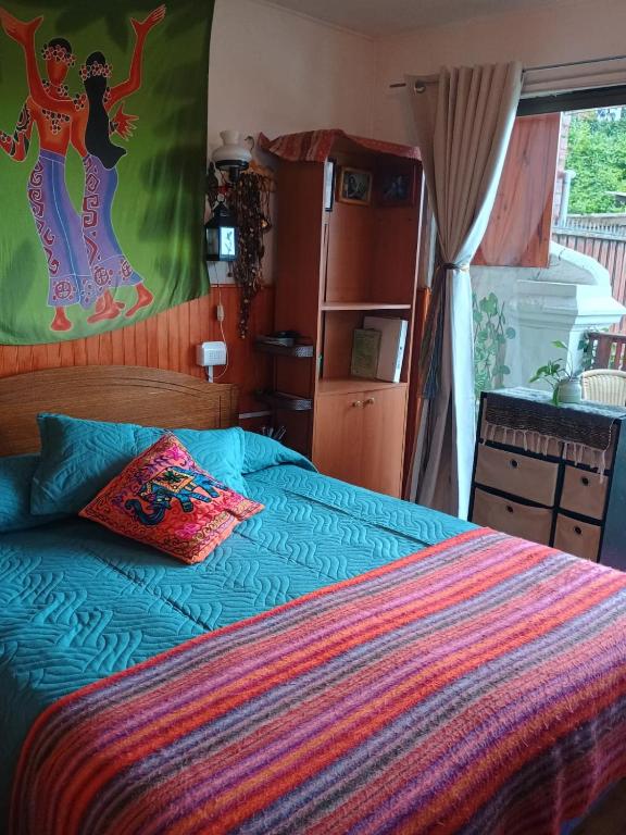 a bedroom with a bed with a colorful blanket at Hermoso loft a pasos del plan de Valparaíso in Valparaíso