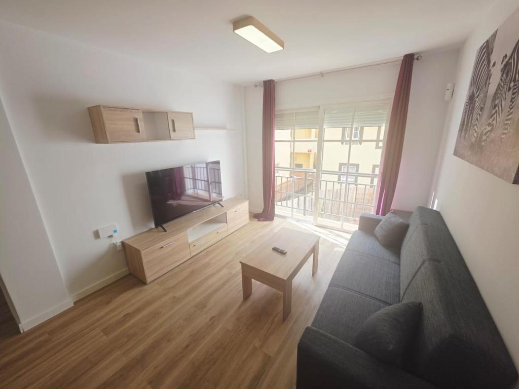 a living room with a couch and a tv at Spacious 3BR Condo With Pool, Wifi & Near Beach in Callao Salvaje