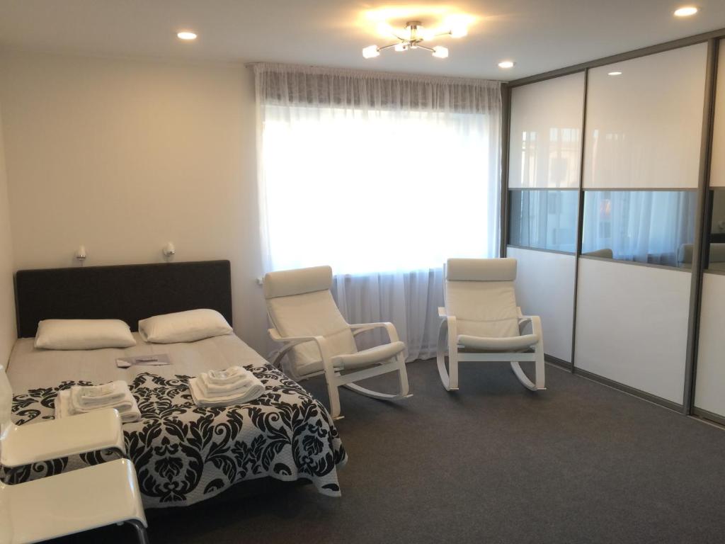 庫爾迪加的住宿－Valentine's White Lux，一间卧室配有床、椅子和窗户