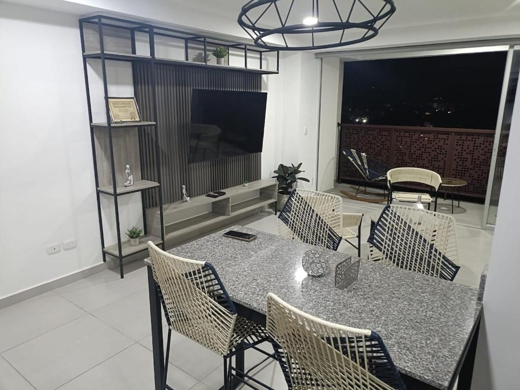 a dining room with a table and chairs and a television at Mandala - Confort y lujo cerca del parque deportivo in Ibagué