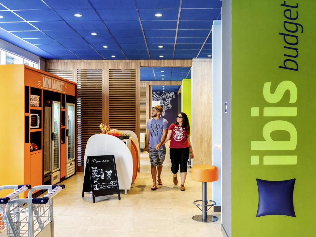 two women walking down a hallway in a store at ibis budget Sao Caetano in São Caetano do Sul
