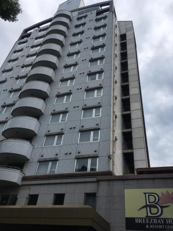 a tall building with a sign in front of it at Breezbay Hotel & Resort Gero in Gero