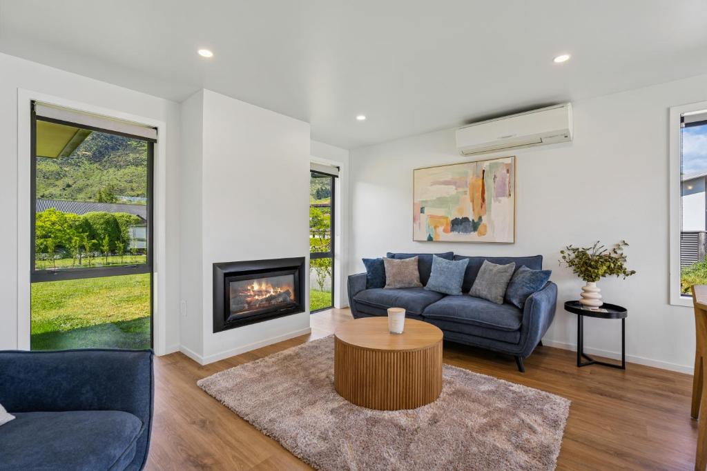 ein Wohnzimmer mit Sofa und Kamin in der Unterkunft Cosy 4 Bedroom Home in Queenstown Airport