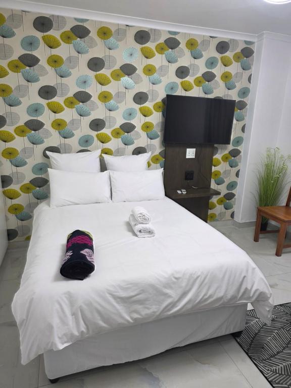 a bedroom with a white bed with a tv on it at The Oceanic 42 in Durban