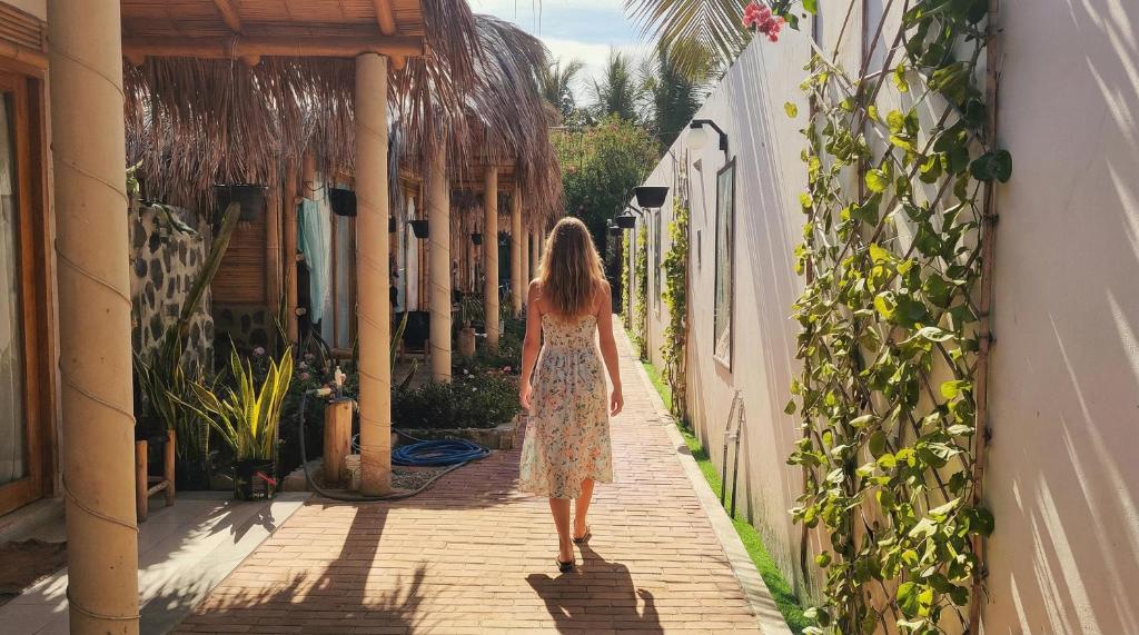 a woman walking down a street in a dress at Puerto Bamboo in Máncora