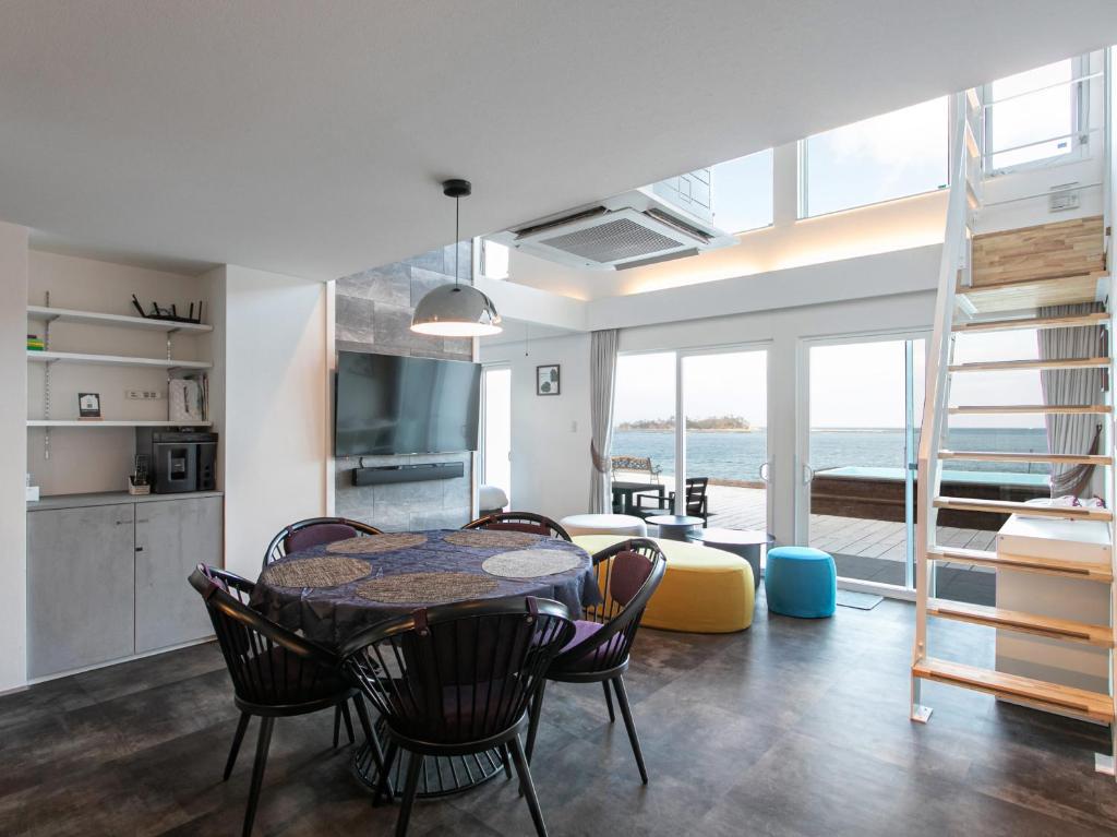 Una cocina y una sala de estar con mesa y sillas. en Kubikai, en Itoshima