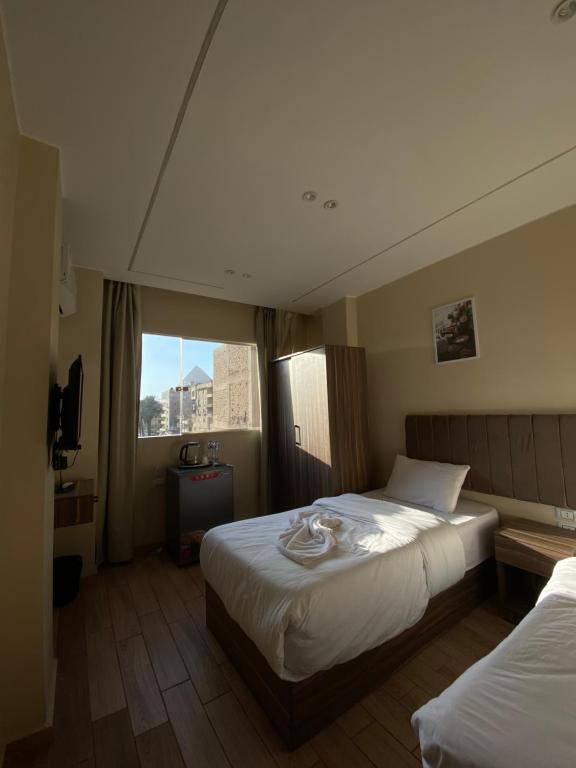 Ένα ή περισσότερα κρεβάτια σε δωμάτιο στο Good Nights Pyramids Hotel