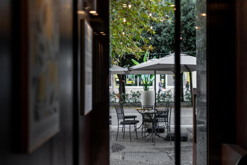 an outside view of a table and chairs with an umbrella at Palazzo Roma- Luxury Leading Hotels in Tirana