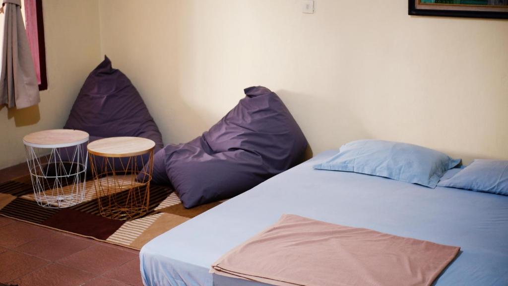 Pondok Kalimaya في سيرانغ: غرفة نوم مع كيسين من الفاصوليا وسرير
