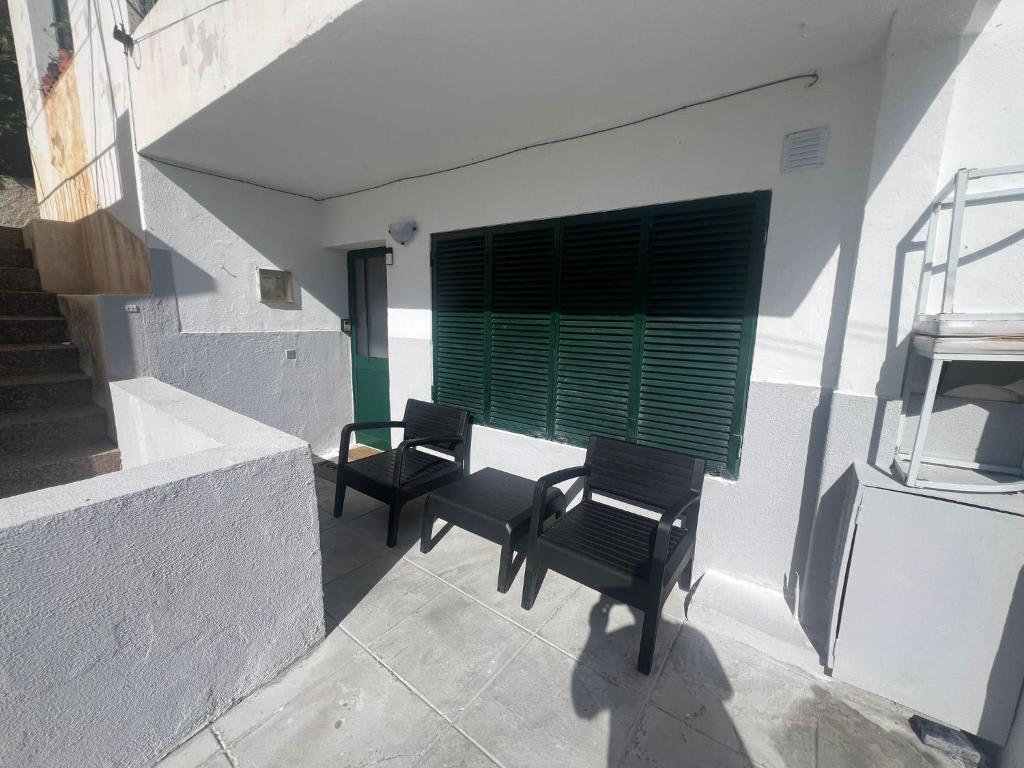two chairs and a window with a green shutter at Serenity Apartment in Funchal